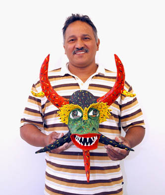 Angel Sánchez Ortiz holding one of his vejigante masks, Puerto Rican carnival  mask making, 2007; Holyoke, Massachusetts; Photography by Maggie Holtzberg