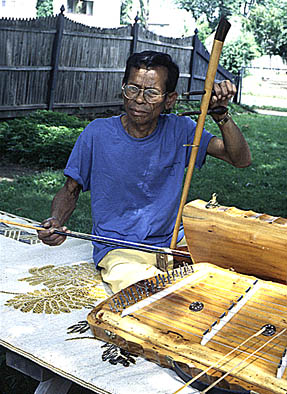 Heang Pen with two of his instruments, Cambodian musical instrument maker and musician, 2000; Heang Meas Pen; Chicopee, Massachusetts; Photography by Jessica Payne