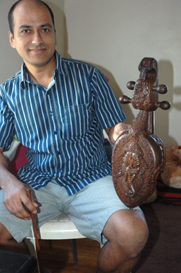 Sushil Gautam holding Nepali sarangee, Nepalese musician, 2014; Sushil Gautam; Somerville, Massachusetts; Photography by Maggie Holtzberg
