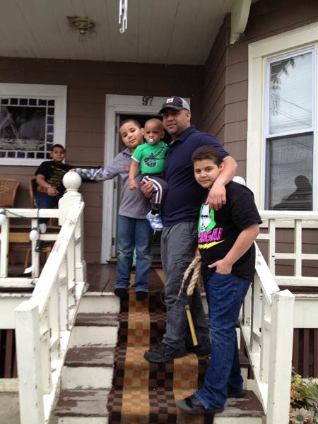 Mirabal family on the front steps of their home; Carnival comparsa; 2013: Lawrence, Massachusetts
